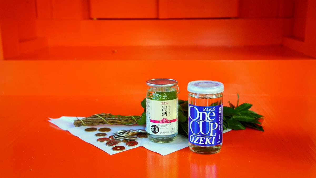 Finished spiced olive oils in glass bottles — one deep red from chili, one golden from cumin and pepper