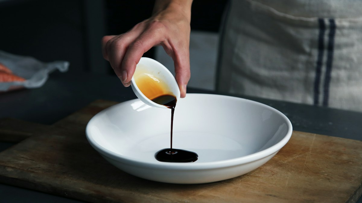 Pouring fresh olive oil into a dressing bowl