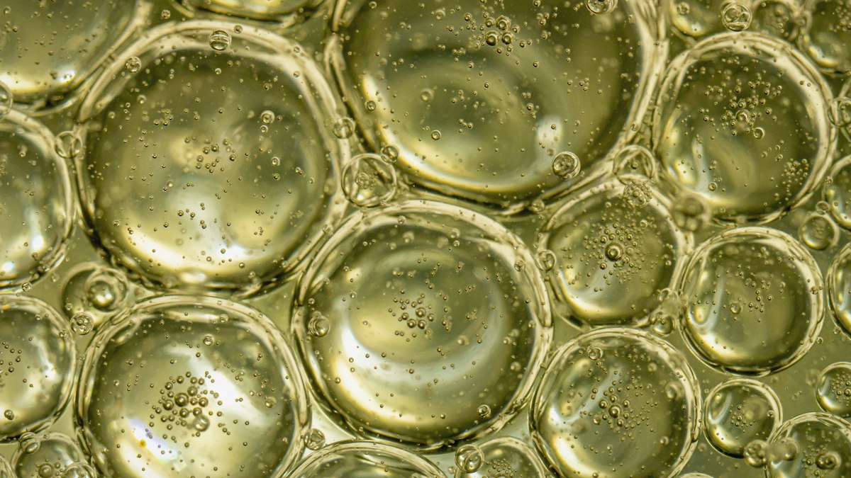 A bottle of extra virgin olive oil just removed from the refrigerator, with the oil partially solidified