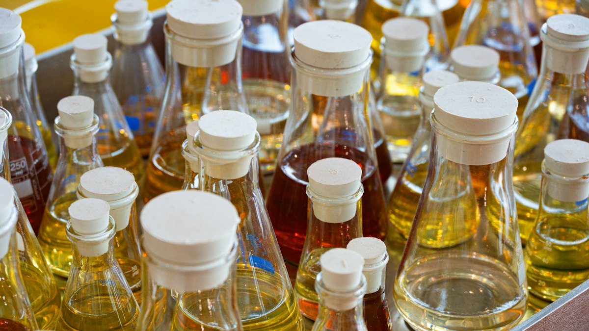 A kitchen shelf lined with bottles of various cold-pressed cooking oils